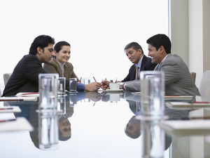 Four Indian business people discussing at conference table